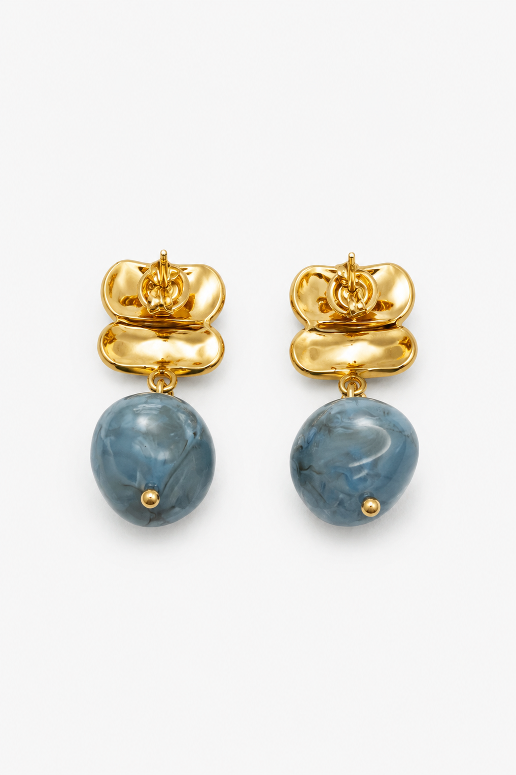 Gold earrings with blue stone drops on a white background
