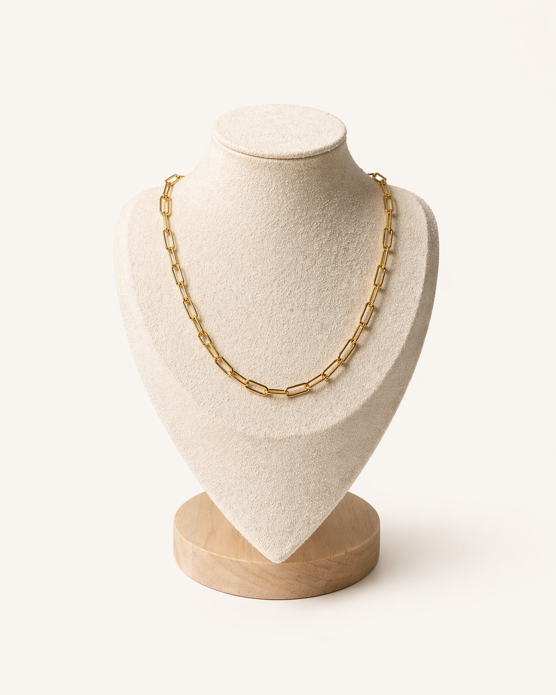Gold chain necklace on a mannequin bust with a white background