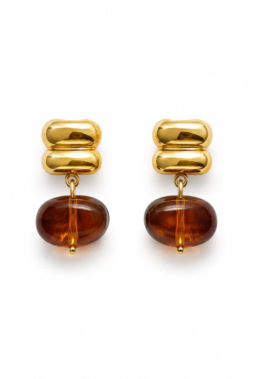 Gold and amber earrings on a white background