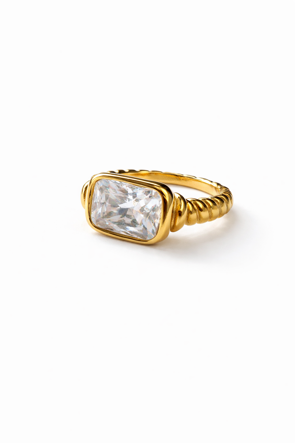Gold ring with a large clear gemstone on a white background
