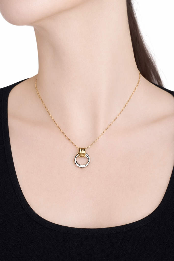 Two tone gold plated necklace with a circular pendant on a model against a white background