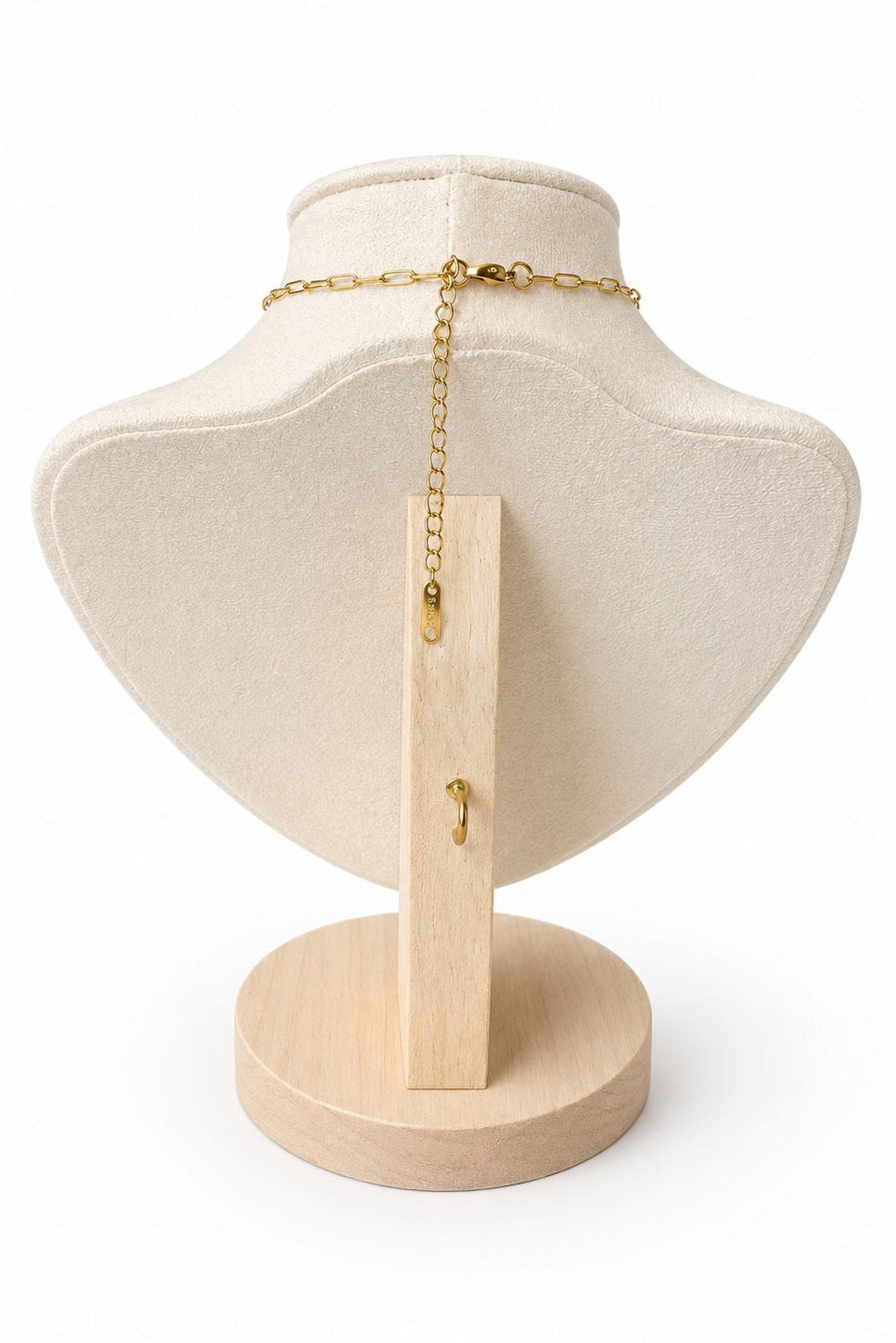 Necklace on a mannequin bust with a wooden stand against a white background