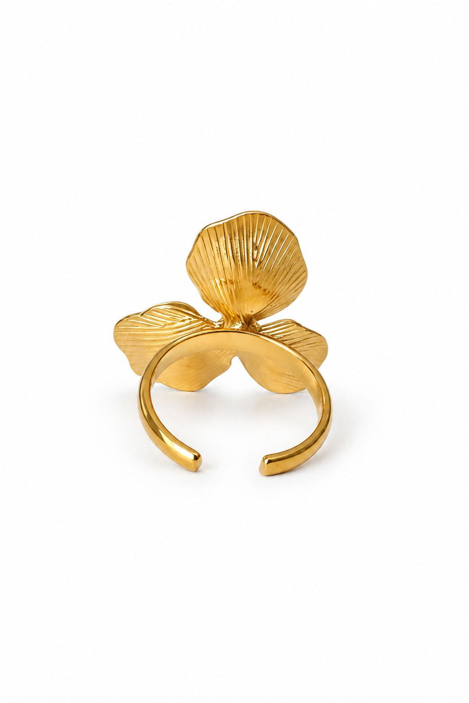 Gold ring with shell-like design on a white background