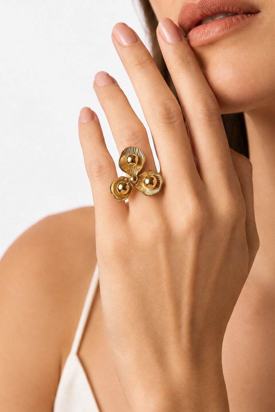 Gold ring on a hand with a neutral background