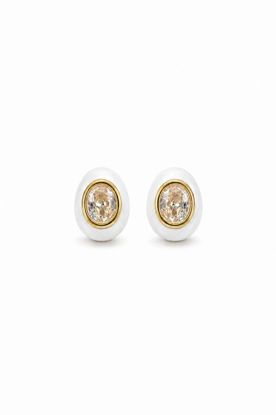Pair of earrings with gold and white design on a white background