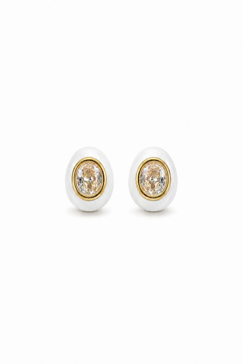 Pair of earrings with gold and white design on a white background