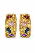 Gold earrings with colorful gemstones on a white background