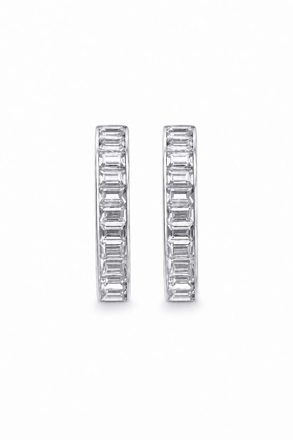 Pair of silver-tone hoop earrings with baguette-cut zircons on a white background