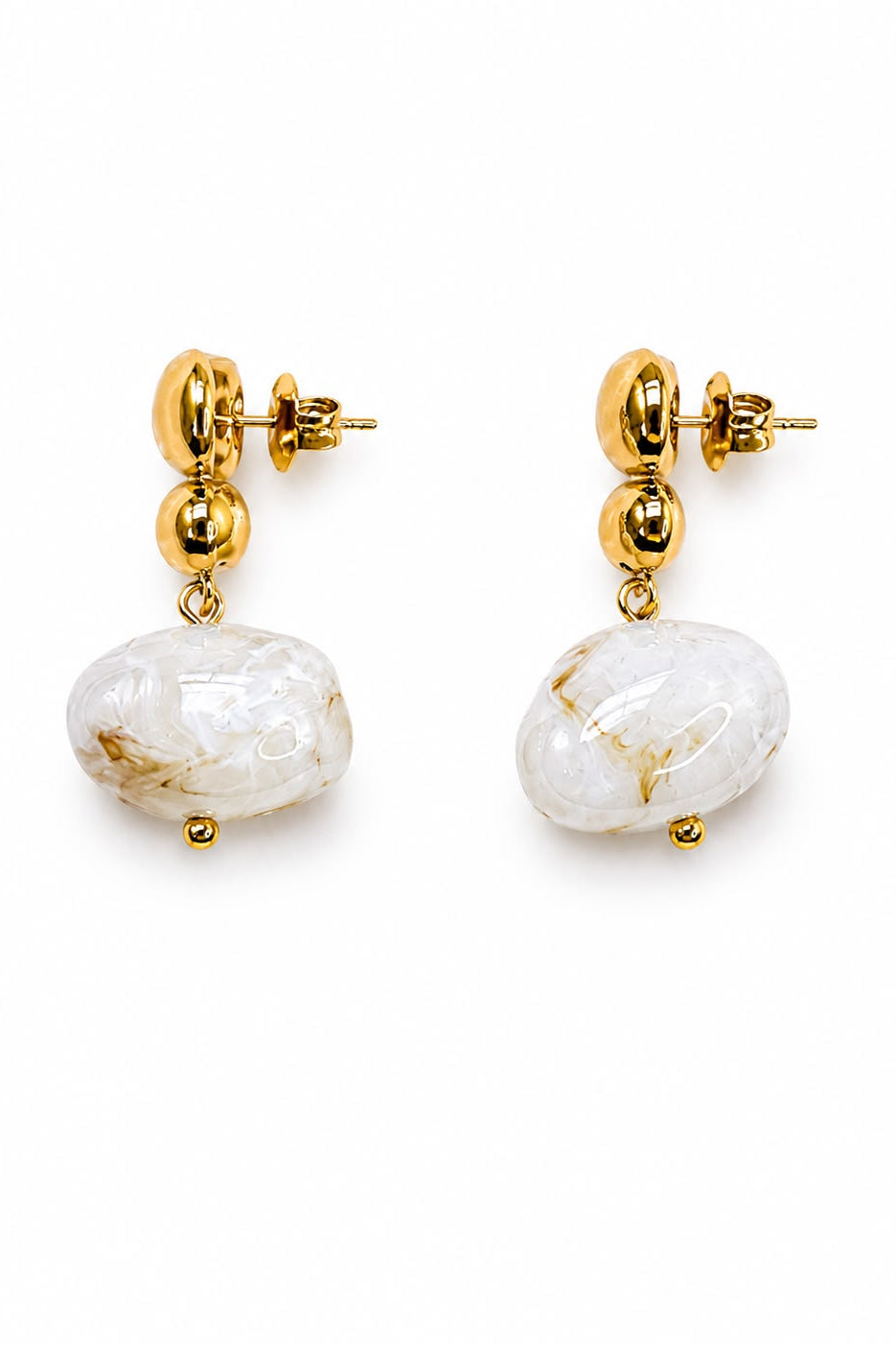 Gold-plated earrings with white marbled stones on a white background