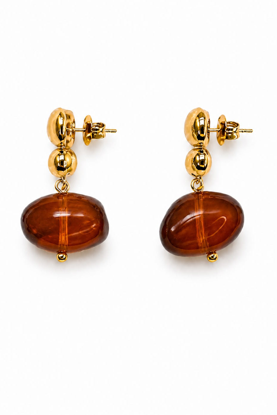 Gold earrings with amber beads on a white background