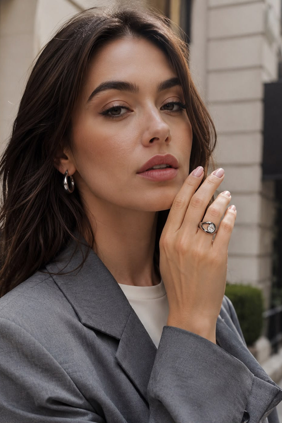 Woman wearing a gray coat with a city street background