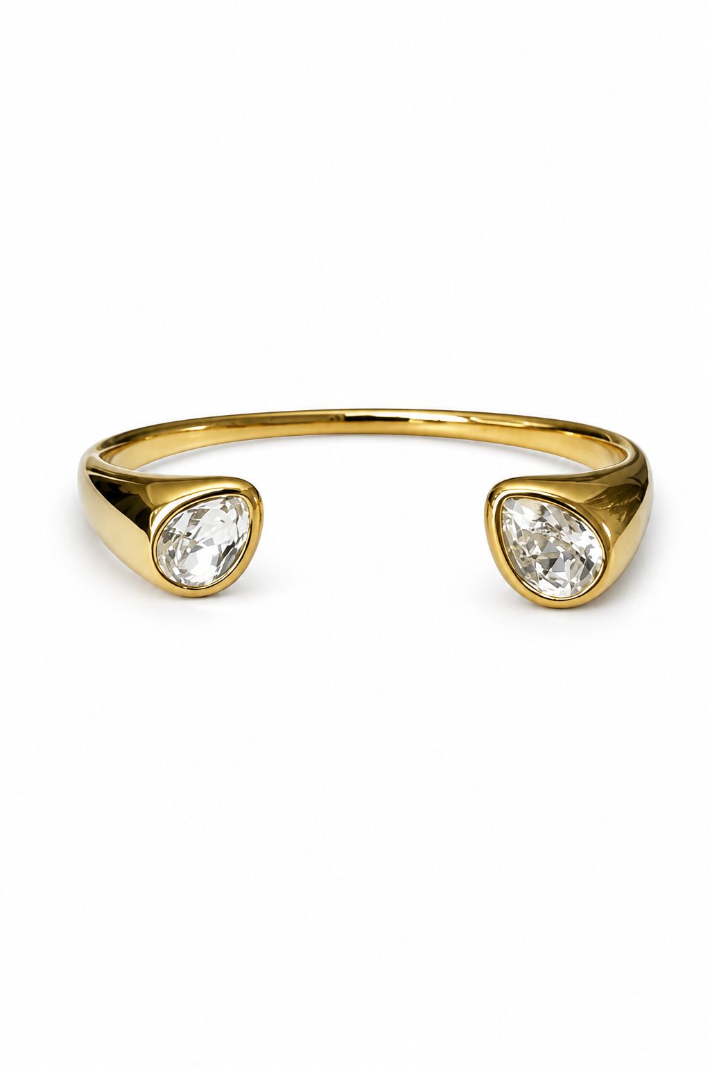 Gold wristlet with two clear gemstones on a white background
